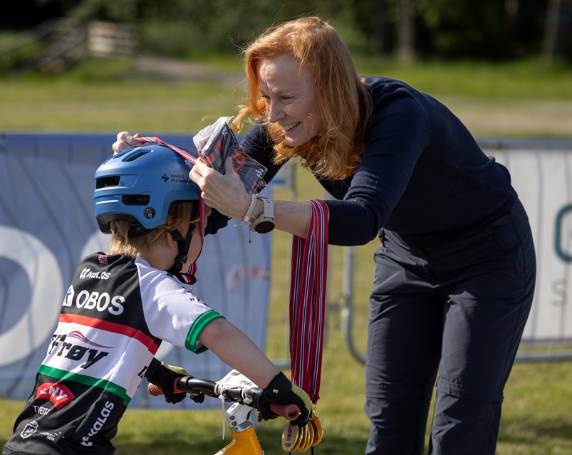 Rikke Rokke fra forbundsstyret satte tydelig pris på å dele ut NM-medaljer til de yngste. Foto: Ingrid B. Helljesen